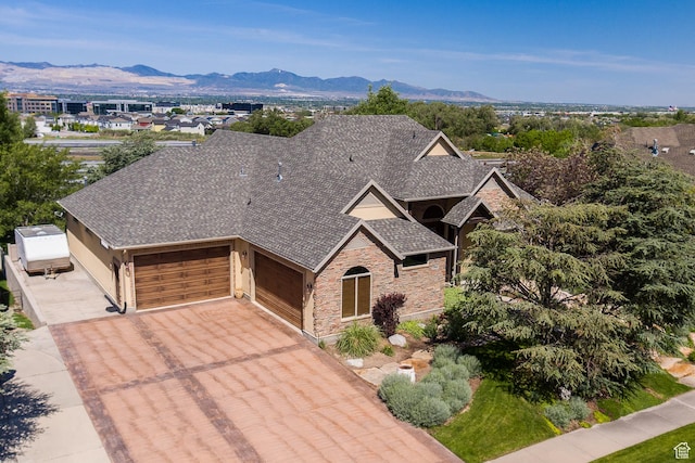 13966 S Arrow Creek Dr E, Draper, UT 84020 - view of front facade featuring a garage, stone siding, a shingled roof, and driveway