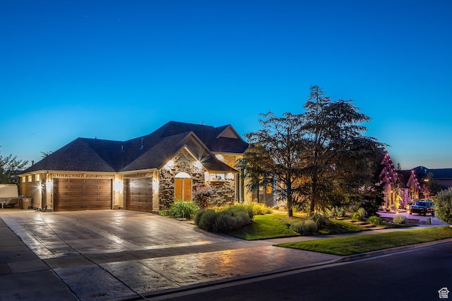 13966 S Arrow Creek Dr E, Draper, UT 84020 - view of front of home featuring an attached garage, driveway, and stone siding