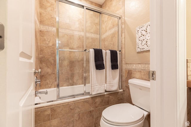 13966 S Arrow Creek Dr E, Draper, UT 84020 - bathroom with tiled shower / bath, toilet, tile walls, and a wainscoted wall