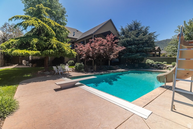 13966 S Arrow Creek Dr E, Draper, UT 84020 - view of swimming pool with a water slide, a patio area, a fenced backyard, and a diving board