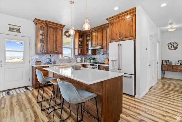 687 E 200 S, Spring City, UT 84662 - kitchen with white refrigerator with ice dispenser, light wood finished floors, tasteful backsplash, a kitchen breakfast bar, and light countertops