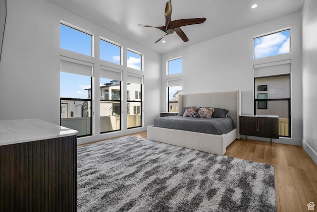 12277 S Emory Peak Cv Unit 404, Herriman, UT 84096 - bedroom with light wood finished floors, recessed lighting, ceiling fan, baseboards, and a towering ceiling
