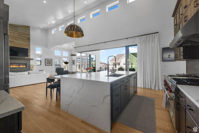12277 S Emory Peak Cv Unit 404, Herriman, UT 84096 - kitchen featuring exhaust hood, appliances with stainless steel finishes, a towering ceiling, open floor plan, and a sink