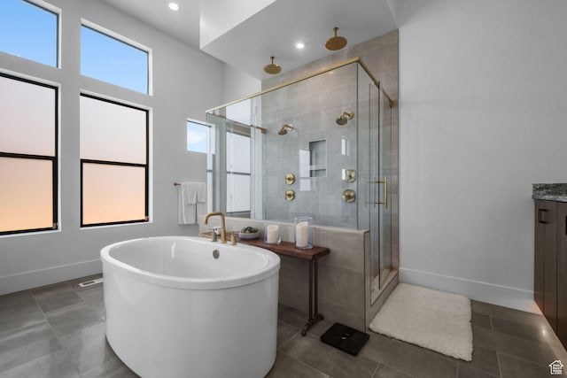 12277 S Emory Peak Cv Unit 404, Herriman, UT 84096 - bathroom with a shower stall, a soaking tub, tile patterned floors, baseboards, and vanity