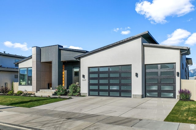 12277 S Emory Peak Cv Unit 404, Herriman, UT 84096 - contemporary home featuring concrete driveway, a garage, stucco siding, and a front lawn