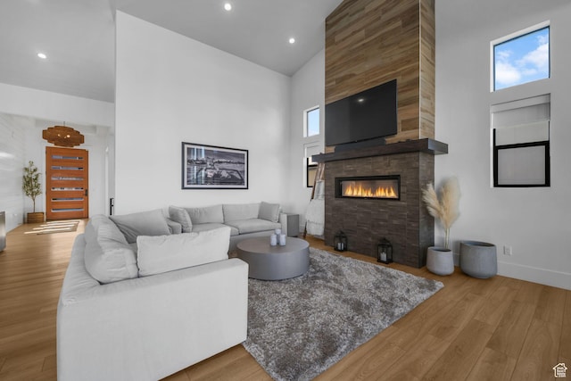 12277 S Emory Peak Cv Unit 404, Herriman, UT 84096 - living room featuring high vaulted ceiling, a large fireplace, wood finished floors, baseboards, and recessed lighting