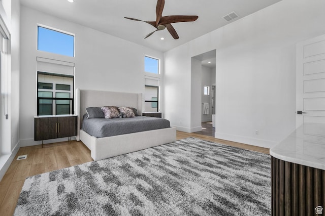 12277 S Emory Peak Cv Unit 404, Herriman, UT 84096 - bedroom featuring wood finished floors, recessed lighting, baseboards, ceiling fan, and connected bathroom