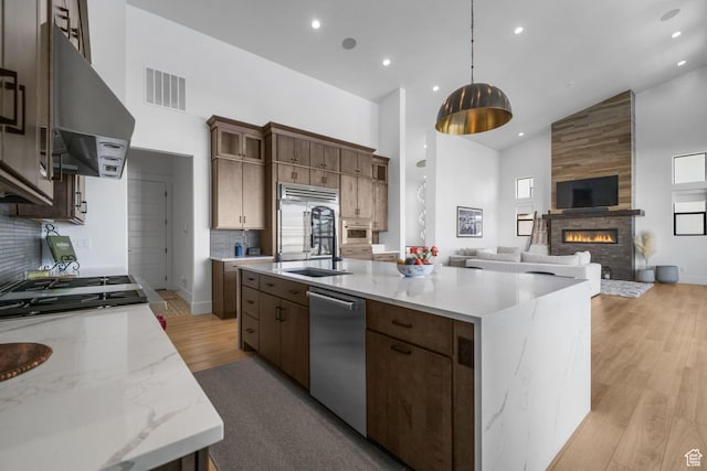 12277 S Emory Peak Cv Unit 404, Herriman, UT 84096 - kitchen with high vaulted ceiling, exhaust hood, appliances with stainless steel finishes, open floor plan, and a sink