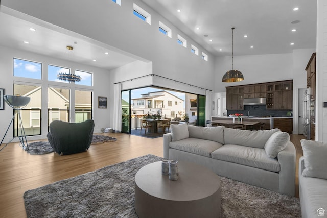 12277 S Emory Peak Cv Unit 404, Herriman, UT 84096 - living room with a towering ceiling, wood finished floors, and recessed lighting