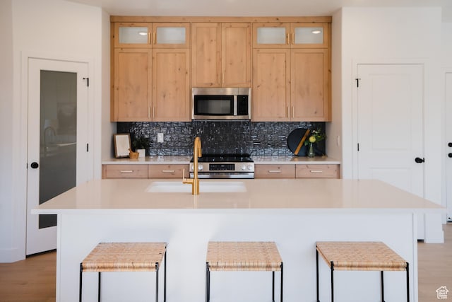 216 E 850 S Unit 6-203, Spanish Fork, UT 84660 - kitchen with appliances with stainless steel finishes, light countertops, tasteful backsplash, and a center island with sink