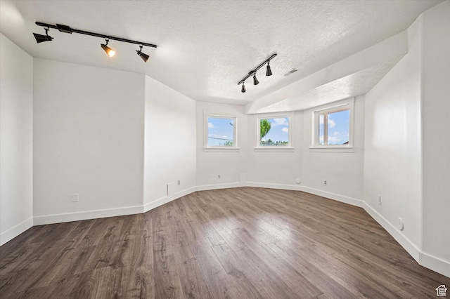 2951 N 1200 E, North Logan, UT 84341 - empty room featuring track lighting, dark wood finished floors, a textured ceiling, and baseboards