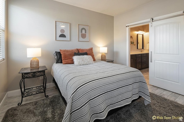 3482 W 150th St N, Hurricane, UT 84737 - bedroom featuring light wood-type flooring, ensuite bathroom, baseboards, and a barn door