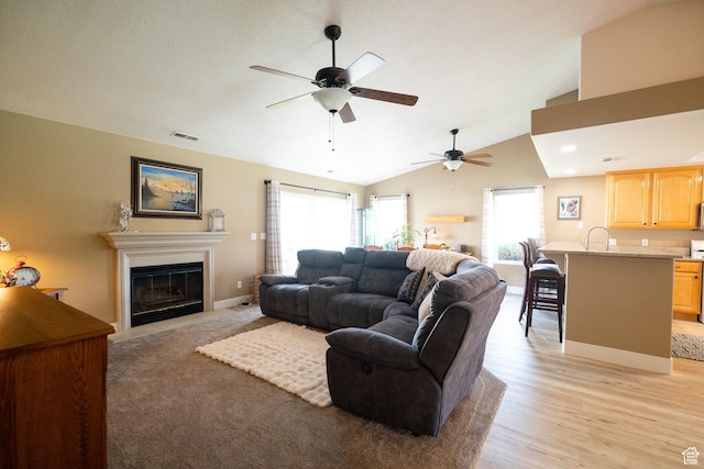 1825 W Mathis Park Pl Unit 13, St George, UT 84770 - living room featuring ceiling fan, a fireplace with flush hearth, vaulted ceiling, light wood finished floors, and baseboards