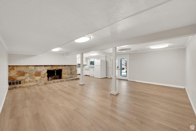 2967 E Branch Dr S, Holladay, UT 84117 - unfurnished living room with light wood-style flooring, baseboards, ornamental molding, and a stone fireplace