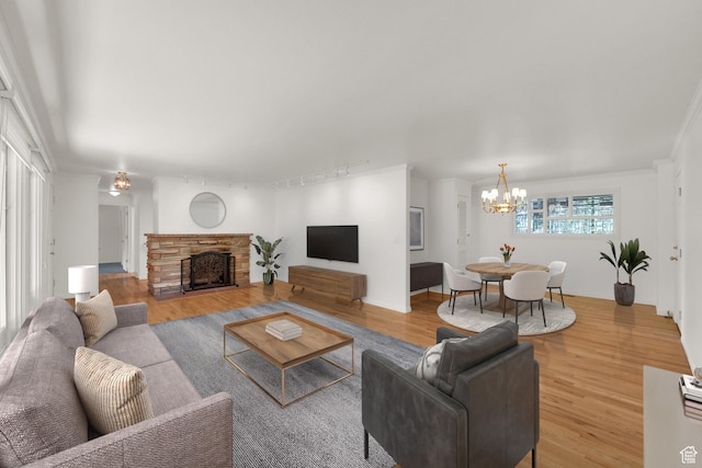2967 E Branch Dr S, Holladay, UT 84117 - living room featuring wood finished floors, a chandelier, a stone fireplace, and track lighting