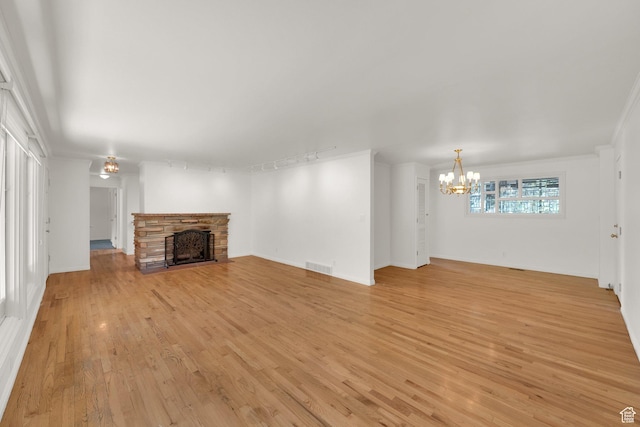 2967 E Branch Dr S, Holladay, UT 84117 - unfurnished living room with a chandelier, a fireplace, light wood-style flooring, and baseboards