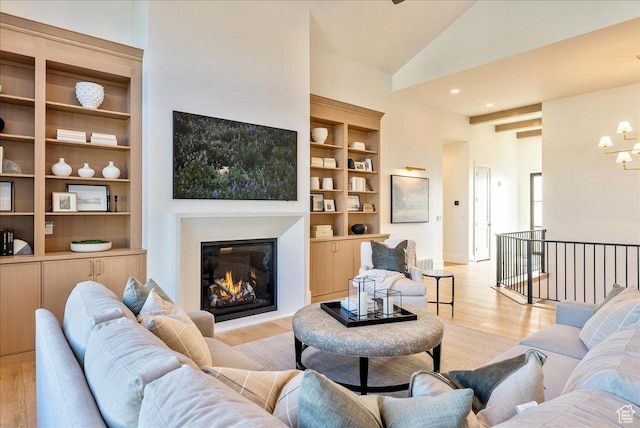 812 N 780 W, American Fork, UT 84003 - living room with light wood finished floors, a glass covered fireplace, built in features, a chandelier, and high vaulted ceiling