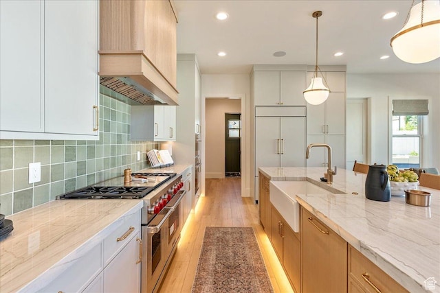 812 N 780 W, American Fork, UT 84003 - kitchen with a sink, range with two ovens, custom exhaust hood, light wood-type flooring, and light stone countertops