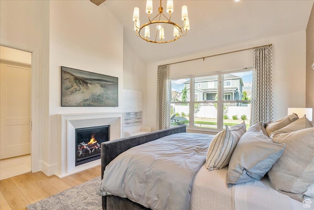 812 N 780 W, American Fork, UT 84003 - bedroom featuring wood finished floors, a chandelier, high vaulted ceiling, a lit fireplace, and baseboards