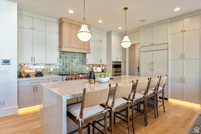812 N 780 W, American Fork, UT 84003 - kitchen featuring light wood-type flooring, stove, an island with sink, decorative backsplash, and recessed lighting
