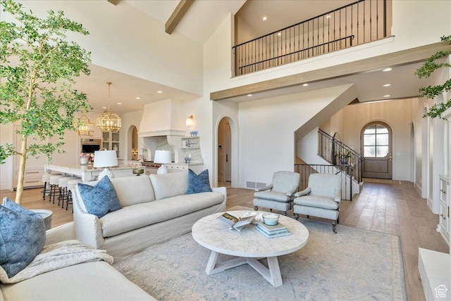 807 N 780 W, American Fork, UT 84003 - living room with arched walkways, a high ceiling, stairway, light wood finished floors, and a chandelier