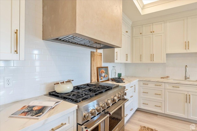 807 N 780 W, American Fork, UT 84003 - kitchen with high end range, a sink, premium range hood, decorative backsplash, and white cabinetry