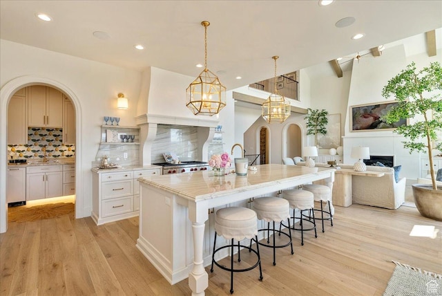 807 N 780 W, American Fork, UT 84003 - kitchen with range, backsplash, light wood-type flooring, a large island with sink, and a kitchen breakfast bar