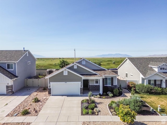 1165 W Silver Hollow Rd, Syracuse, UT 84075 - view of front of property with concrete driveway, a garage, a mountain view, a porch, and stone siding