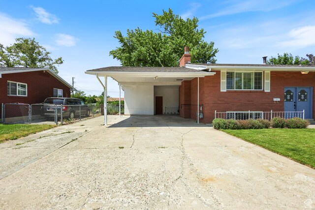 533 N 700 E, Orem, UT 84097 - view of front of house with concrete driveway, a carport, brick siding, and a chimney