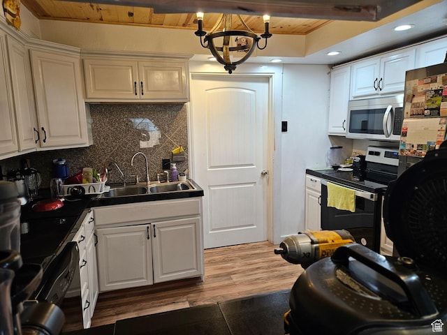 920 N 100 E, Pleasant Grove, UT 84062 - kitchen with stainless steel appliances, a sink, backsplash, a chandelier, and white cabinetry