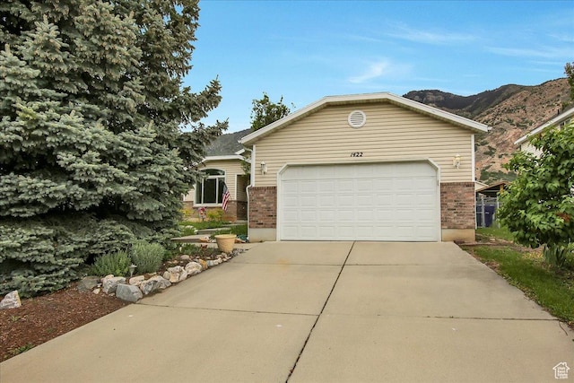 1422 N Fowler Ave E, Ogden, UT 84404 - ranch-style home with brick siding, driveway, an attached garage, and a mountain view