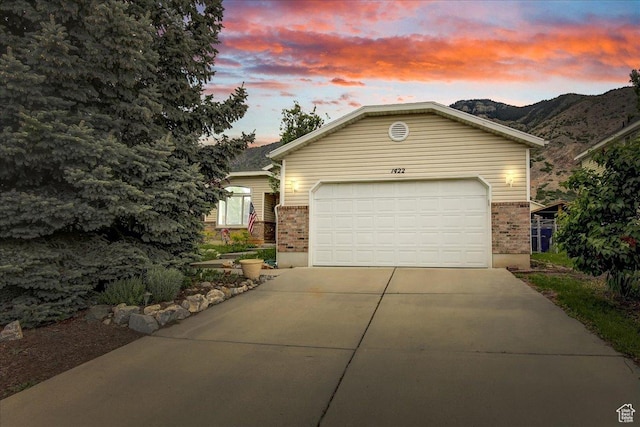 1422 N Fowler Ave E, Ogden, UT 84404 - ranch-style home featuring brick siding, driveway, a garage, and a mountain view