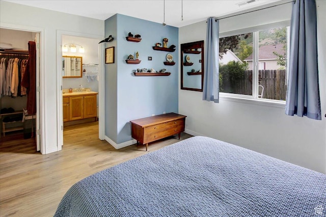 1422 N Fowler Ave E, Ogden, UT 84404 - bedroom with light wood-style floors, baseboards, a spacious closet, a sink, and ensuite bath