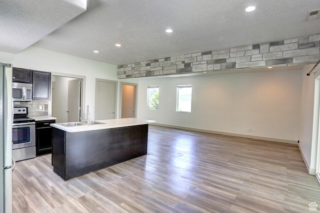 247 E 700 N, Spanish Fork, UT 84660 - kitchen with appliances with stainless steel finishes, light countertops, a textured ceiling, open floor plan, and a sink