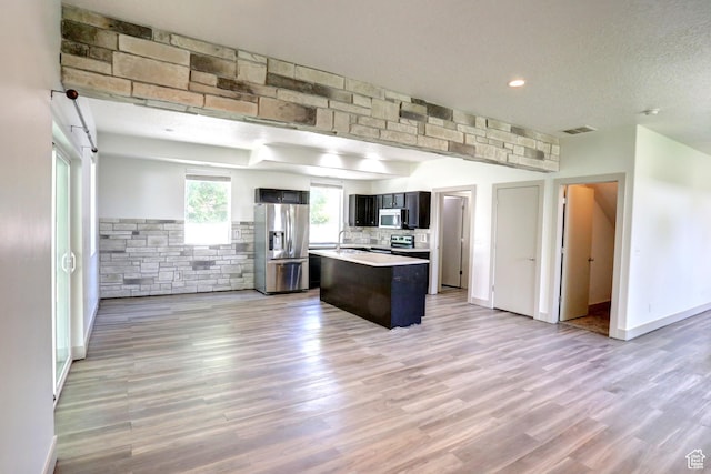 247 E 700 N, Spanish Fork, UT 84660 - kitchen with stainless steel appliances, light countertops, light wood-style floors, a sink, and a kitchen island with sink