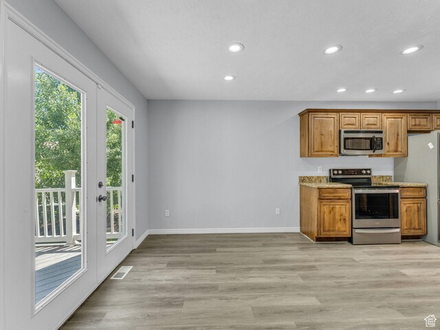 8335 S 1050 E, Sandy, UT 84094 - kitchen featuring appliances with stainless steel finishes, recessed lighting, baseboards, brown cabinetry, and light wood-style floors