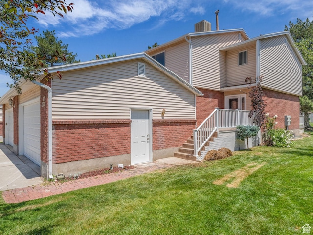 8335 S 1050 E, Sandy, UT 84094 - rear view of property featuring brick siding, a lawn, an attached garage, concrete driveway, and central air condition unit