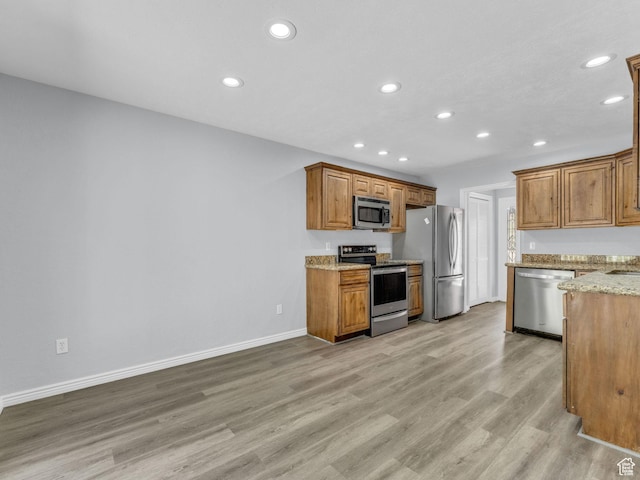 8335 S 1050 E, Sandy, UT 84094 - kitchen with stainless steel appliances, recessed lighting, light wood-type flooring, baseboards, and light stone counters