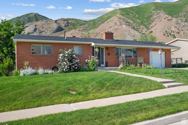 1185 E Hillcrest Dr, Springville, UT 84663 - ranch-style home featuring a chimney, an attached garage, brick siding, and a front yard