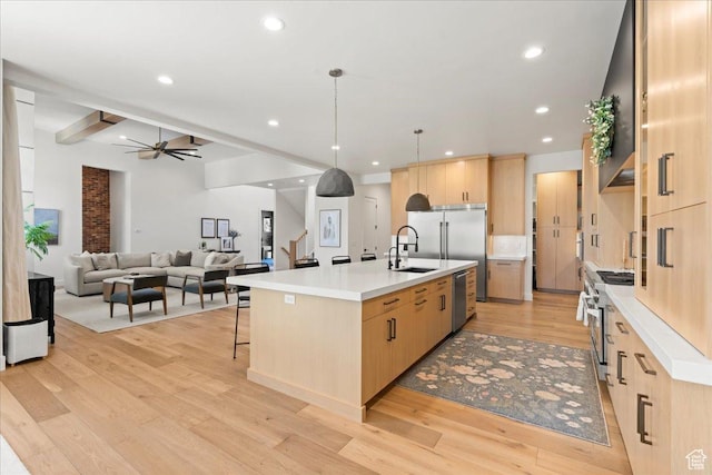 11527 S River Front Pkwy W, South Jordan, UT 84095 - kitchen featuring light brown cabinetry, premium appliances, light wood-style flooring, an island with sink, and ceiling fan
