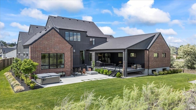 11527 S River Front Pkwy W, South Jordan, UT 84095 - back of property with brick siding, a patio, a hot tub, and a lawn