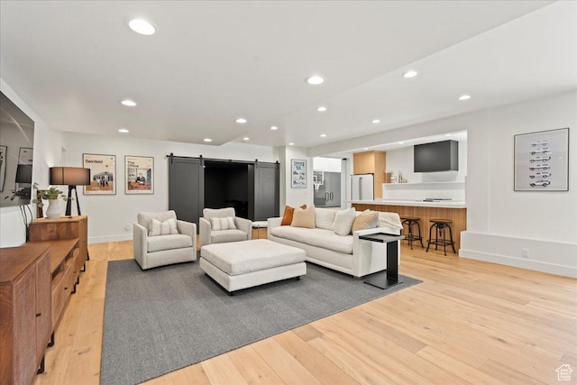 11527 S River Front Pkwy W, South Jordan, UT 84095 - living area with a barn door, light wood-style flooring, recessed lighting, and baseboards
