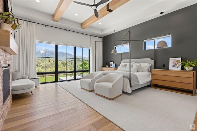 11527 S River Front Pkwy W, South Jordan, UT 84095 - bedroom featuring beamed ceiling, a brick fireplace, a high ceiling, wood finished floors, and a mountain view
