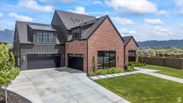 11527 S River Front Pkwy W, South Jordan, UT 84095 - view of front of property with board and batten siding, an attached garage, driveway, brick siding, and a mountain view