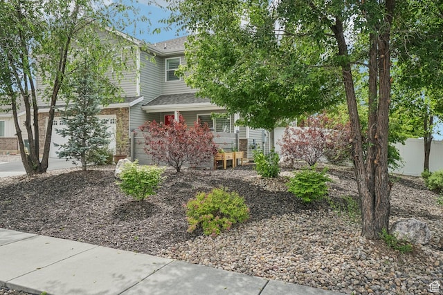 157 N Keogh Ln W, Ogden, UT 84404 - view of front of house with covered porch, a shingled roof, and brick siding