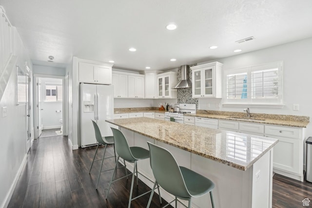 157 N Keogh Ln W, Ogden, UT 84404 - kitchen featuring white appliances, wall chimney range hood, a breakfast bar, white cabinets, and a sink