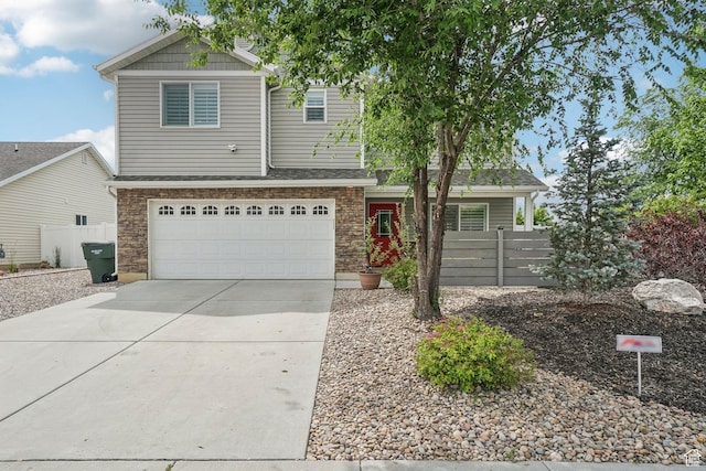 157 N Keogh Ln W, Ogden, UT 84404 - view of front of property with concrete driveway, an attached garage, and stone siding