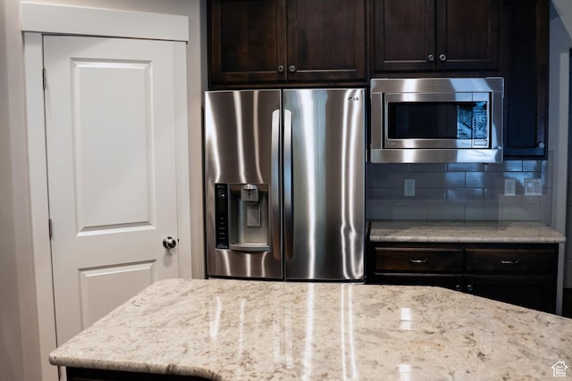 66 N 325th St E, Farmington, UT 84025 - kitchen with stainless steel appliances, tasteful backsplash, dark brown cabinets, and light stone counters