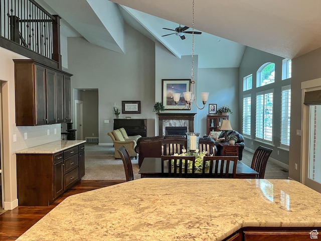 66 N 325th St E, Farmington, UT 84025 - dining area featuring a premium fireplace, high vaulted ceiling, ceiling fan, dark wood-style flooring, and baseboards