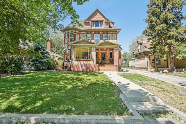2683 S Jefferson Ave E, Ogden, UT 84401 - victorian-style house with covered porch, a front lawn, and brick siding
